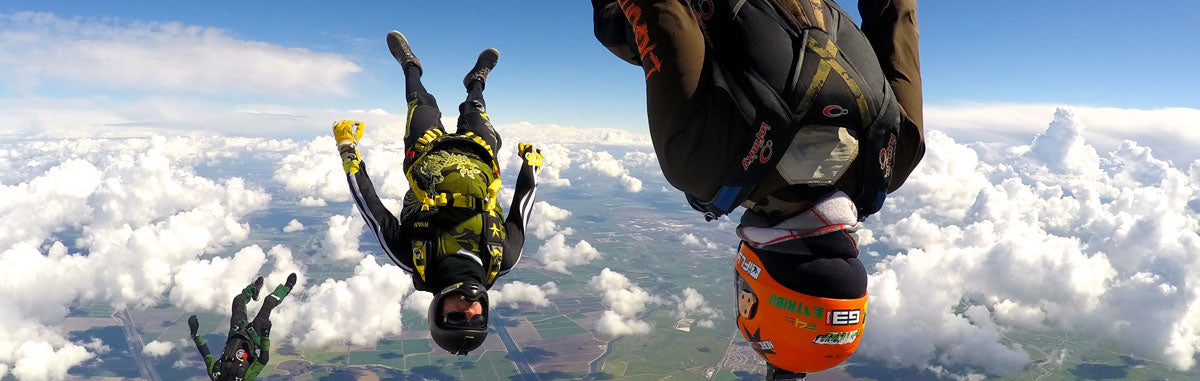 Skydivers in freefall wearing VSE Infinity containers