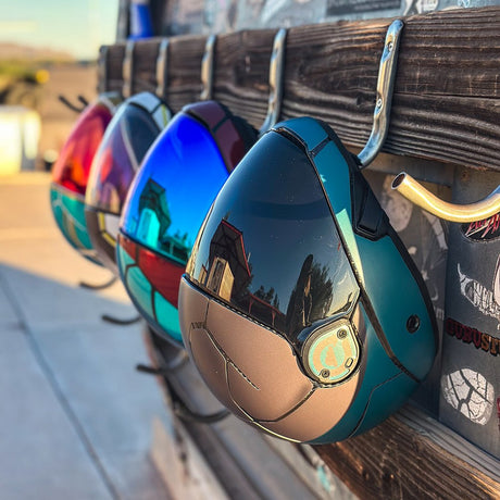 Cookie C45 skydiving helmet in a teal custom finish displayed with other helmets