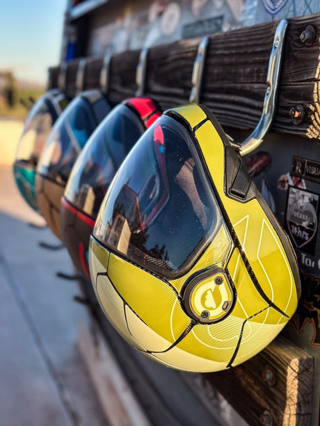 Cookie C45 skydiving helmet in a yellow custom finish displayed with other helmets